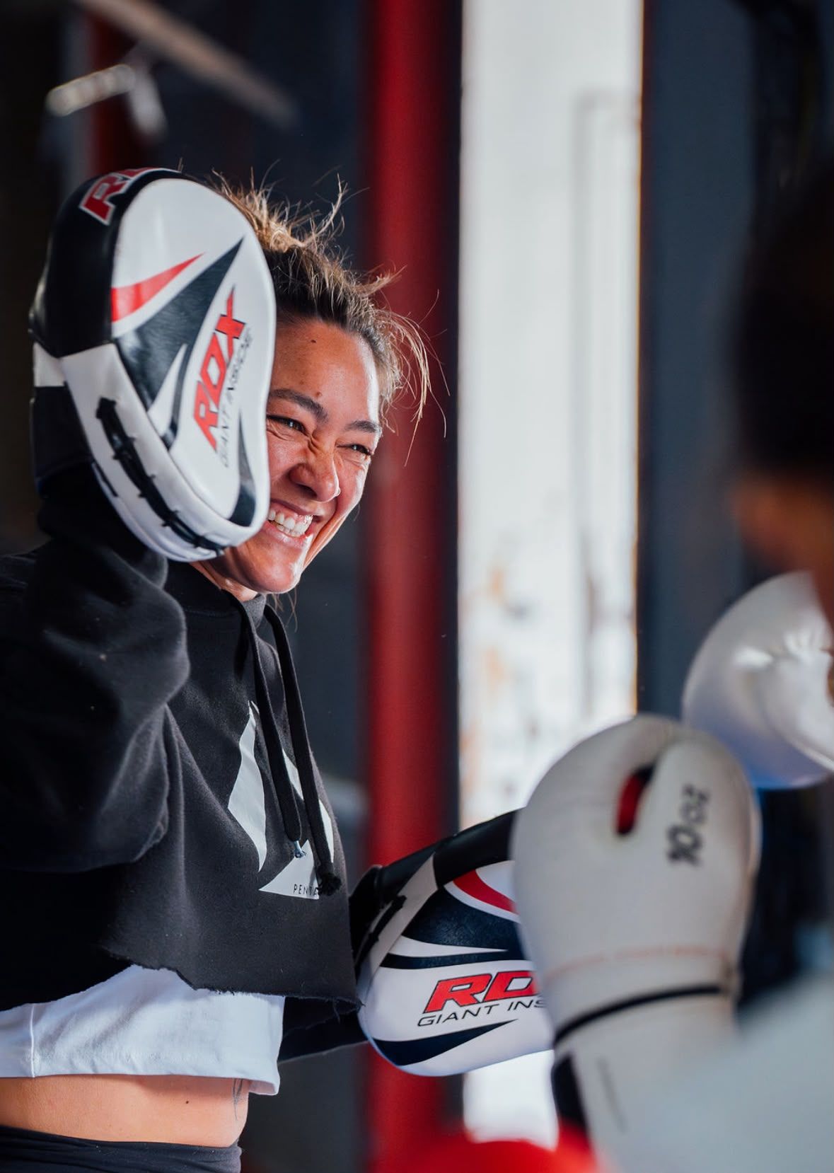 Dokas a rir, com uma manopla de treino de boxe.