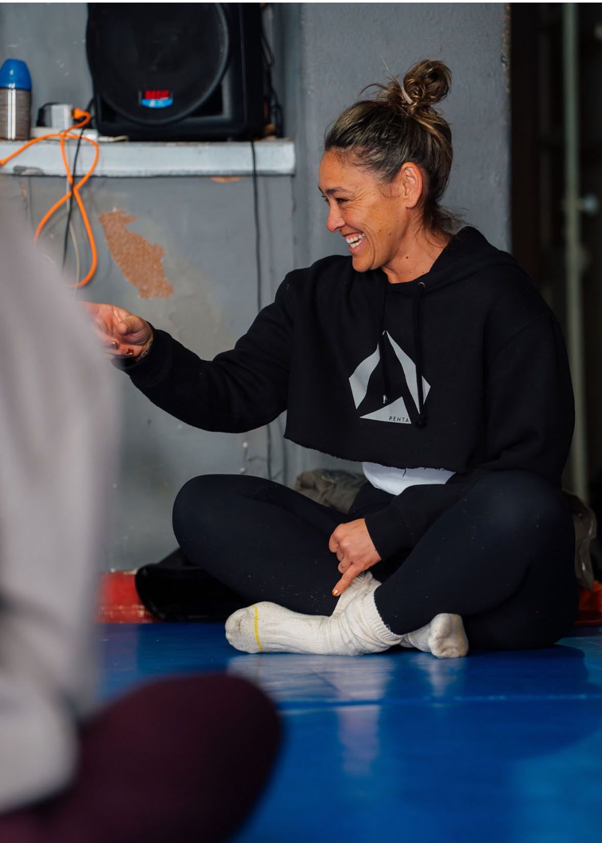 Dokas sentada no tapete de treino, a sorrir.