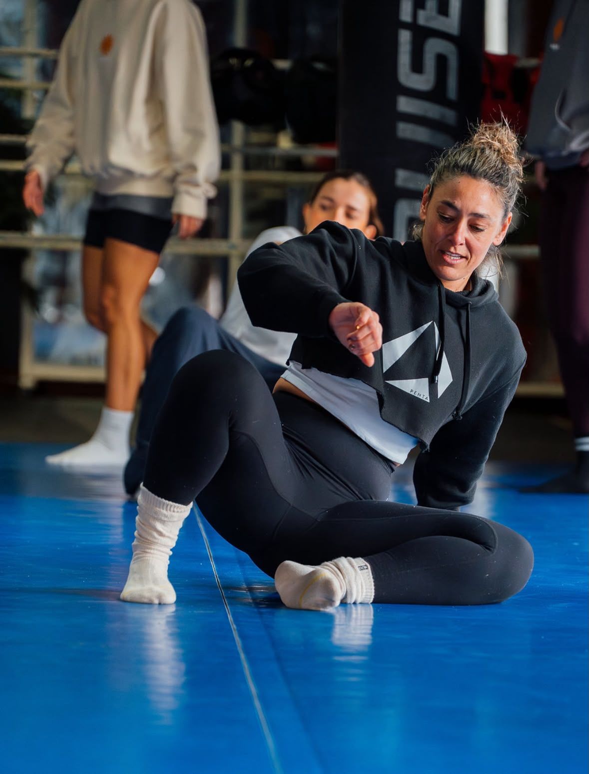 Dokas no tapete de treino, a demonstrar um movimento a partir do chão.